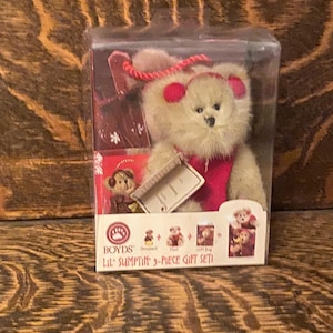 May include: A boxed set of three plush teddy bears. The set includes a bear wearing a red Santa hat and a red scarf, a bear wearing a red Santa hat, and a bear wearing a red Santa hat and a red scarf. The box is labelled "Boyd's Lil' Sumptin' 3-Piece Gift Set".