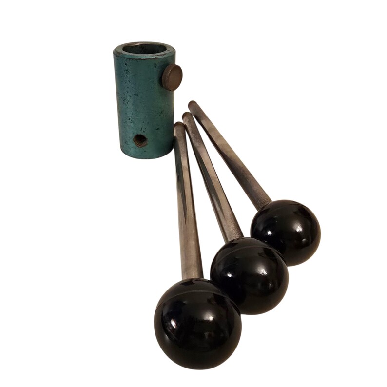 May include: A teal-colored metal cylinder with a bronze-colored knob and three black-knobbed levers. The levers have silver-colored stems. The items are set against a white background.