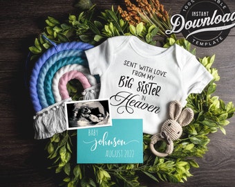 May include: A white onesie with the text "Sent with love from my Big Sister in Heaven" and a blue and pink rainbow hanging above it. A blue card with the text "Baby Johnson August 2022" is in the foreground.