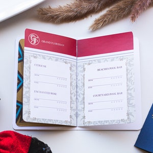 May include: A small, red, white and gold booklet with the words "Grand Floridian" on the cover. The booklet is open to reveal a list of drinks and food available at the Citricos, Enchanted Rose, Beaches Pool Bar and Courtyard Pool Bar.