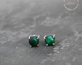 Puede incluir: Un par de pendientes de plata con piedras de malaquita verde.