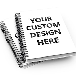 May include: Two white spiral bound notebooks with black wire binding. The top notebook has the text "YOUR CUSTOM DESIGN HERE" printed in black.