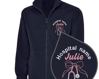 May include: Navy blue fleece jacket with a full zipper and a high collar. The jacket features an embroidered design of a stethoscope and bow, with the text "Hospital name Julie".