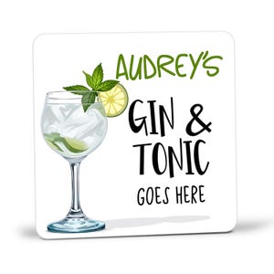 May include: White square coaster with the text "Audrey's Gin & Tonic goes here" in black lettering. A glass of gin and tonic with a lime wedge and mint garnish is pictured.