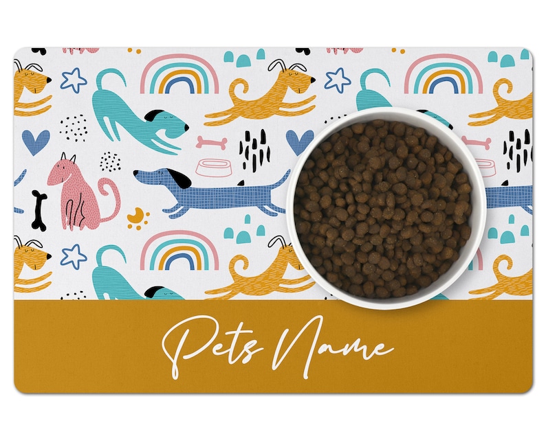 May include: White dog bowl with brown kibble on a white and yellow dog-themed placemat with the text "Pets Name" in white on a yellow background.