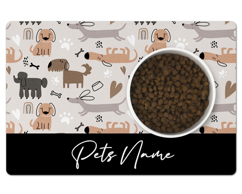May include: A gray and white dog-themed pet bowl mat with a white bowl filled with brown dog food. The mat has a black border with the text "Pets Name" in white.