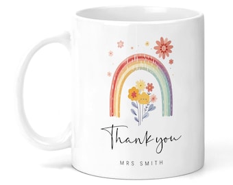 May include: White ceramic mug with a rainbow and flowers design. The text "Thank you" and "MRS SMITH" is printed on the mug.
