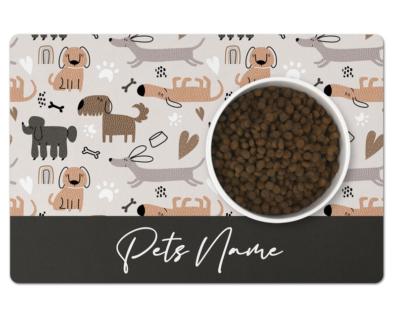 May include: A white dog bowl with brown dog food inside, sitting on a gray and white dog-themed placemat with the text "Pets Name" at the bottom.
