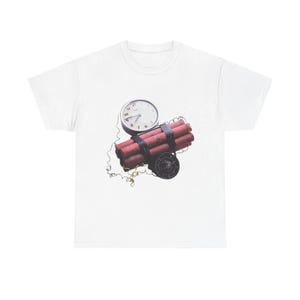 Pode incluir: Camiseta branca com um gráfico de um maço de dinamite, um relógio e um temporizador. A dinamite é vermelha e preta, com um mostrador de relógio mostrando a hora. A camisa é feita de um material macio e confortável.