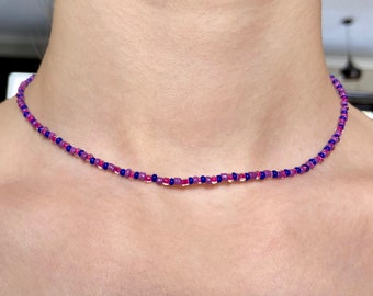 Könnte beinhalten: Eine zarte Choker-Kette aus kleinen rosa und blauen Perlen.