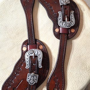 Handmade Tooled Leather western spur straps with Horse Shoe brand buckles and loops.