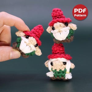 May include: Three crocheted gnome ornaments with red hats and white beards. The gnomes are wearing green and brown clothing. The image includes the text "PDF Pattern".