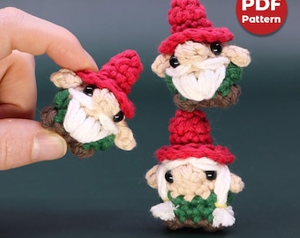 Op de afbeelding: Drie gehaakte gnome-versieringen met rode mutsen en witte baarden. De gnomes dragen groene en bruine kleding. De afbeelding bevat de tekst "PDF Pattern".