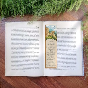 May include: An open book with a Bible bookmark. The bookmark is a counted cross-stitch pattern showing a castle and the text "You are my strength, I sing praise to you, you God are my fortress, my God on whom I can rely. Psalms 59:17."