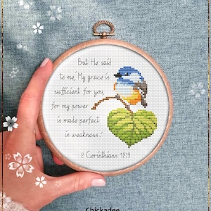 May include: A cross stitch pattern featuring a blue and orange chickadee perched on a green leaf with the text "But He said to me, My grace is sufficient for you, for my power is made perfect in weakness - 2 Corinthians 12:19".