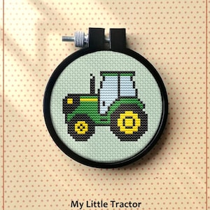 Pu&ograve; includere: Uno schema di punto croce contato per un trattore verde e giallo. Lo schema &egrave; in un cerchio da ricamo nero e il testo "My Little Tractor" e "Counted cross stitch pattern" &egrave; sotto il cerchio. Il testo "PDF" &egrave; nell'angolo in basso a destra.