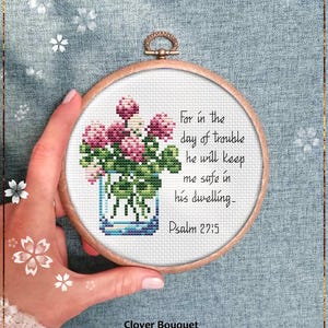 May include: A counted cross stitch pattern featuring a bouquet of pink clover flowers in a glass vase. The pattern includes the text "For in the day of trouble he will keep me safe in his dwelling - Psalm 27:5".