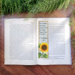 Könnte beinhalten: Ein gezähltes Kreuzstichmuster für ein Lesezeichen mit einer Sonnenblume und dem Bibelvers "Denn so viele Verheißungen Gottes sind, sie sind in Christus ja." - 2 Korinther 1:20.