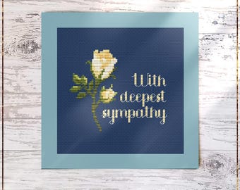 Può includere: Uno schema di punto croce contato con una rosa bianca e il testo "With deepest sympathy". Lo schema è su uno sfondo blu ed è incorniciato da un bordo blu chiaro.