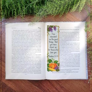 May include: Open Bible with a colorful, cross-stitched bookmark. The bookmark features text from Psalms 31:19, a pumpkin, and grapes. The words "Bible Bookmark Psalms 31" are at the bottom.