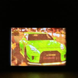 Può includere: Un'auto sportiva verde brillante dal design elegante. L'auto ha una linea bassa, una griglia anteriore prominente e uno spoiler. L'immagine è ben illuminata, evidenziando i dettagli dell'auto e il testo "LB PERFORMANCE" sulla parte anteriore.