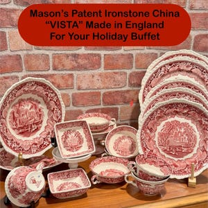 May include: A collection of red and white Mason's Patent Ironstone China "VISTA" dishes, including plates, bowls, and cups. The dishes feature a scenic design and are arranged on a wooden surface. The text in the image reads "Made in England For Your Holiday Buffet."