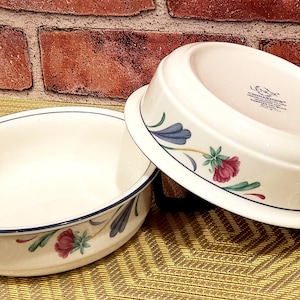 May include: Two white ceramic bowls with blue and green floral designs. The bowls are made by Lenox and are part of the "Charleston" collection.