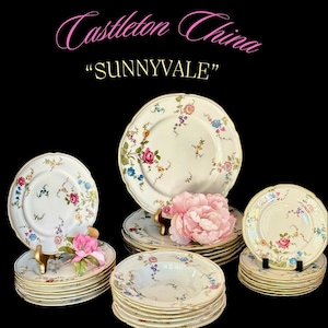 May include: A set of vintage Castleton China "Sunnyvale" dinnerware in a cream color with a floral pattern. The set includes plates, bowls, and saucers.