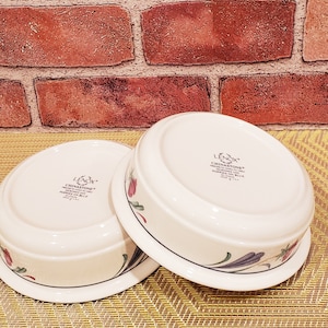 May include: Two white ceramic bowls with floral designs. The bowls are made by Lenox and are part of the Chinastone Poppy's in Blue collection.