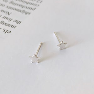 May include: A pair of silver star stud earrings. The earrings are small and delicate, with a simple star design.