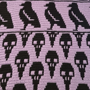 May include: A purple crocheted blanket with a repeating pattern of black ravens and skulls.