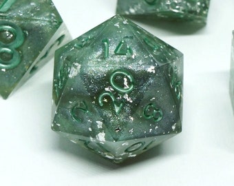 May include: A set of seven polyhedral dice in various shapes, perfect for tabletop games. The dice are a translucent green with silver flecks and green numbering. The dice are arranged on a white surface.