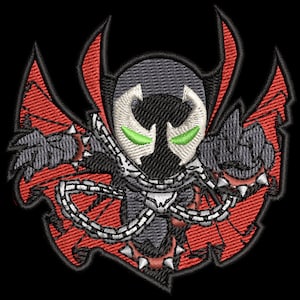 Puede incluir: Un parche bordado rojo y negro con un personaje de dibujos animados con una capa y cadenas. El personaje tiene una cara blanca y negra con ojos verdes.