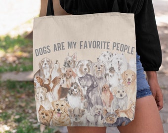 May include: A beige canvas tote bag with the text "Dogs are my favorite people" printed in gray. The bag is decorated with a collage of watercolor illustrations of various dog breeds.
