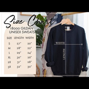 May include: Size chart for a unisex Gildan sweatshirt. The chart shows the length and width in inches for sizes S, M, L, XL, 2X, and 3X. A black sweatshirt is shown hanging on a hanger.