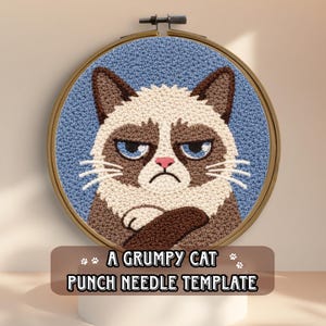 May include: A round punch needle template featuring a grumpy cat design. The cat has a brown and white face with a frown, blue eyes, and crossed arms. The background is blue, and the text "A GRUMPY CAT PUNCH NEEDLE TEMPLATE" is below the image.