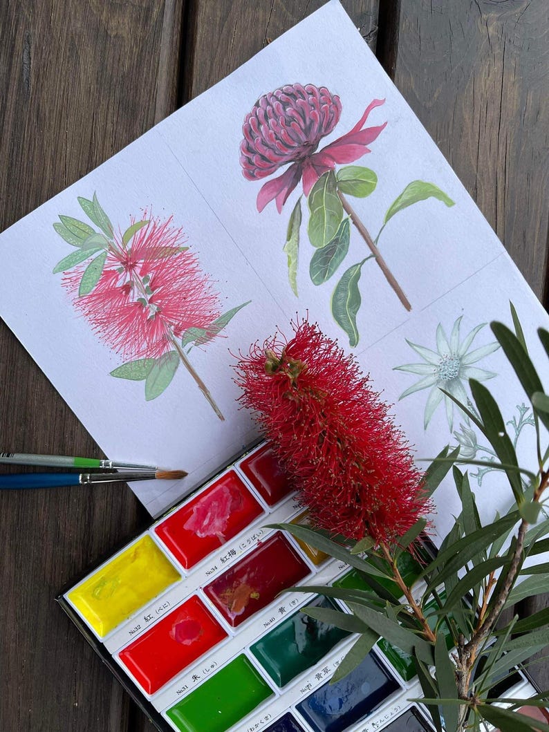 Pu&ograve; includere: Acquerello di fiori rossi e rosa con foglie verdi. Una tavolozza di acquerelli con vari colori &egrave; accanto al dipinto. Sono visibili anche dei pennelli.
