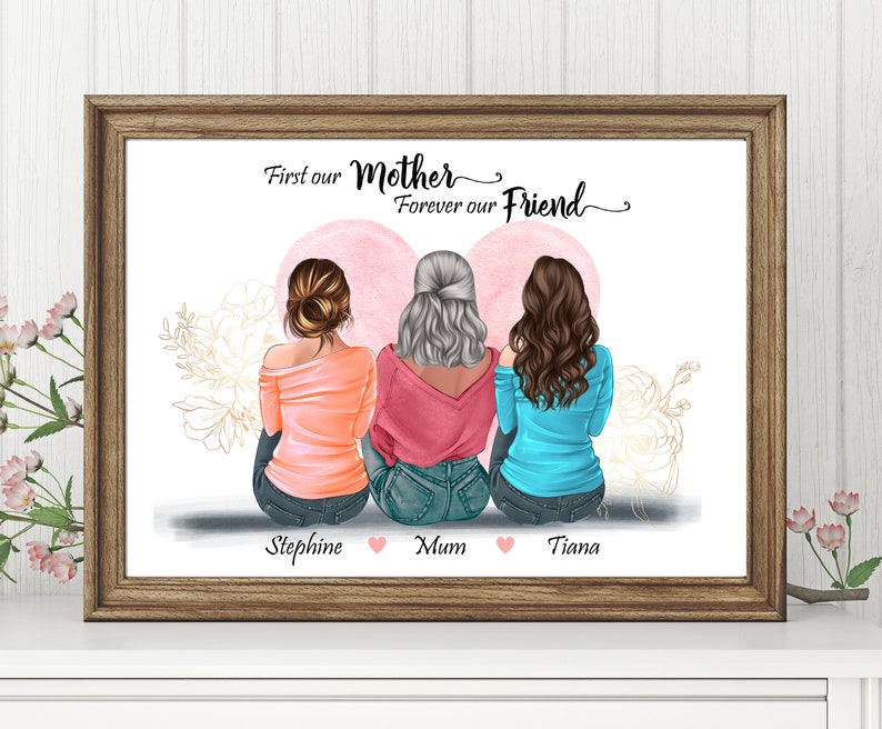 May include: A framed print with a watercolor heart design featuring three women sitting back to back. The text reads "First our Mother Forever our Friend" with the names "Stephine, Mum, Tiana" below.