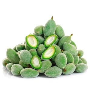 May include: A pile of fresh, green almonds, some whole and some sliced open to reveal the white nut inside. The almonds have a fuzzy, green exterior and are set against a white background.