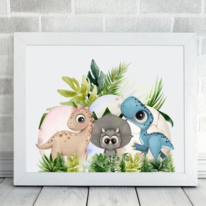 May include: A watercolor illustration of three cartoon dinosaurs in a nest of eggs. The dinosaurs are a blue triceratops, a brown stegosaurus, and a green tyrannosaurus. The dinosaurs are surrounded by green leaves and flowers.