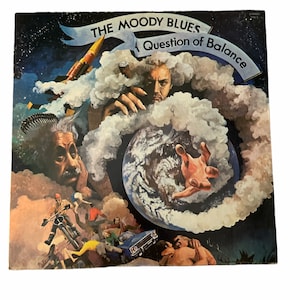 May include: A vintage vinyl record album cover featuring a psychedelic illustration of a hand holding a globe surrounded by clouds and people. The album title is "The Moody Blues: A Question of Balance".