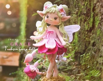 May include: A crocheted fuchsia fairy doll with a pink and white dress, green hair, and white wings. The doll has a flower crown and is standing on a mossy surface. The text "CROCHET PATTERN GRACE Fuchsia fairy doll" is visible.