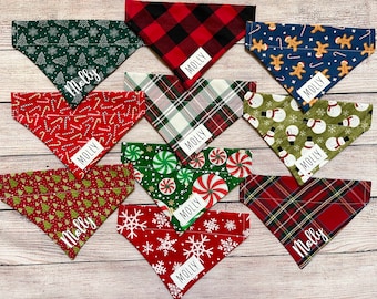 May include: A collection of festive dog bandanas in various Christmas-themed patterns. Designs include Christmas trees, candy canes, gingerbread men, snowmen, plaid, and snowflakes. Each bandana has a white label with the name "Molly".