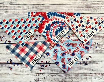May include: Five different patterned bandana style dog collars with the name "Finley" printed on each. The bandanas are in red, white, and blue with patterns of stars, tie-dye, ice cream, gingham, and sunglasses.