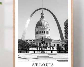 May include: Black and white framed print featuring the Gateway Arch and the Old Courthouse in St. Louis, Missouri. The print includes the text "ST. LOUIS UNITED STATES OF AMERICA" at the bottom, set against a light wood frame.