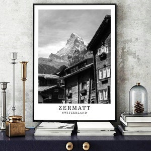 May include: Black and white photograph of a mountain village in Zermatt, Switzerland. The Matterhorn mountain is in the background. The text "Zermatt Switzerland" is at the bottom of the image.