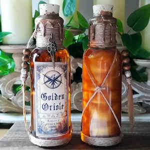 May include: Two amber glass bottles with cork stoppers and twine wrapped around the necks. The bottles contain a golden liquid and have labels that read "Golden Oriole" and "renders a witcher's body immune to poison".
