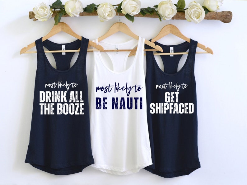 Op de afbeelding: Drie marineblauwe tanktops met witte tekst. De tekst op de tops luidt "most likely to drink all the booze", "most likely to be nauti" en "most likely to get shipfaced".