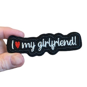 May include: Black embroidered patch with white text that reads "I love my girlfriend!" and a red heart.
