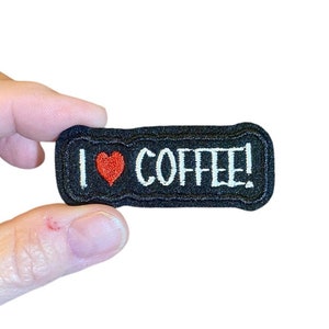 May include: Black embroidered patch with white text that reads "I love coffee!" and a red heart.